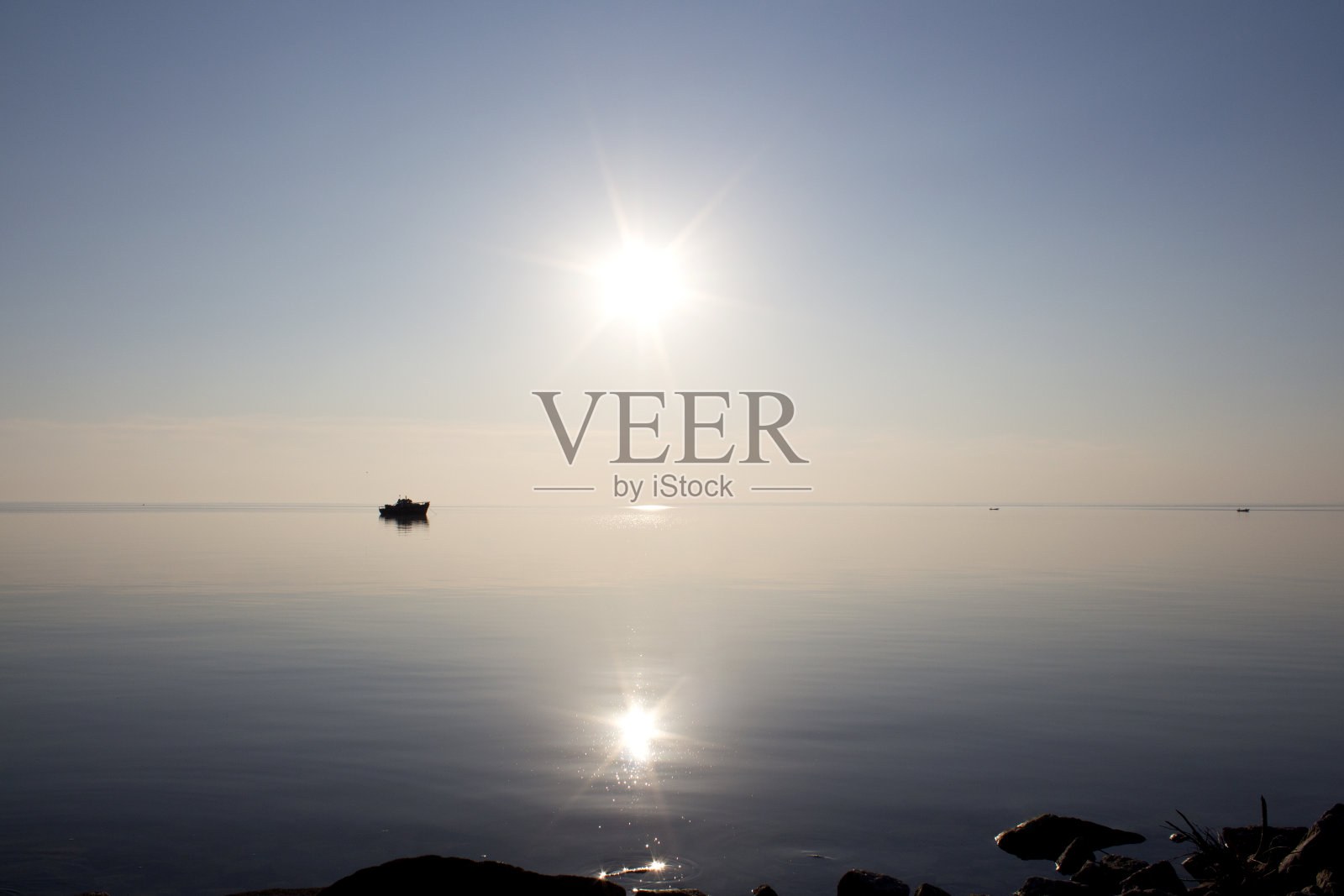 日落时一只漂浮的船的剪影照片摄影图片