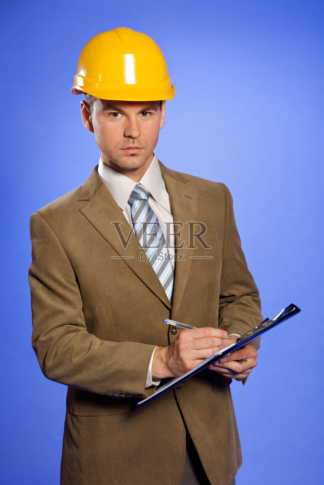 商人的肖像在黄色安全帽写在剪贴板上照片摄影图片