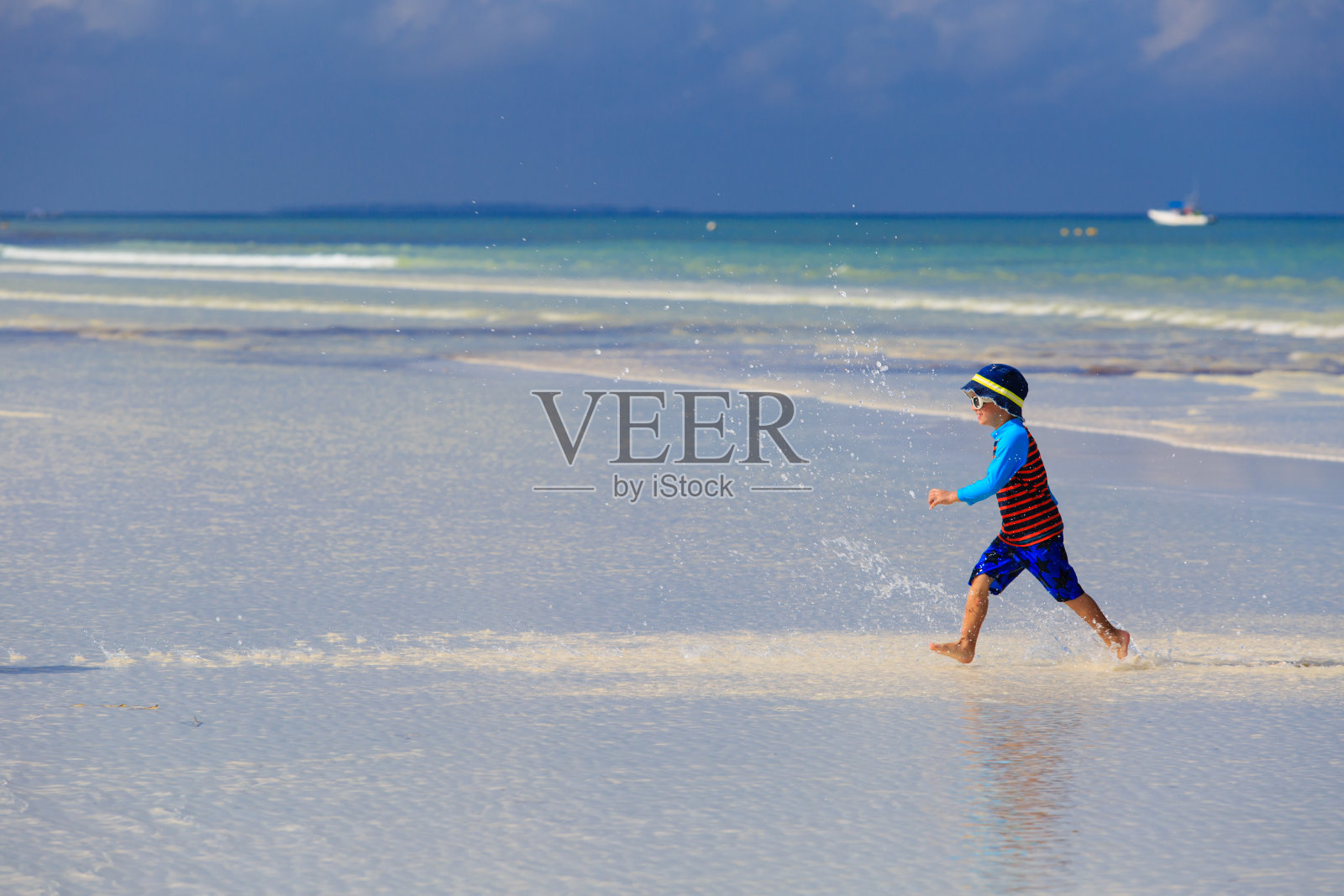 快乐的小男孩在夏天的海滩上跑步照片摄影图片