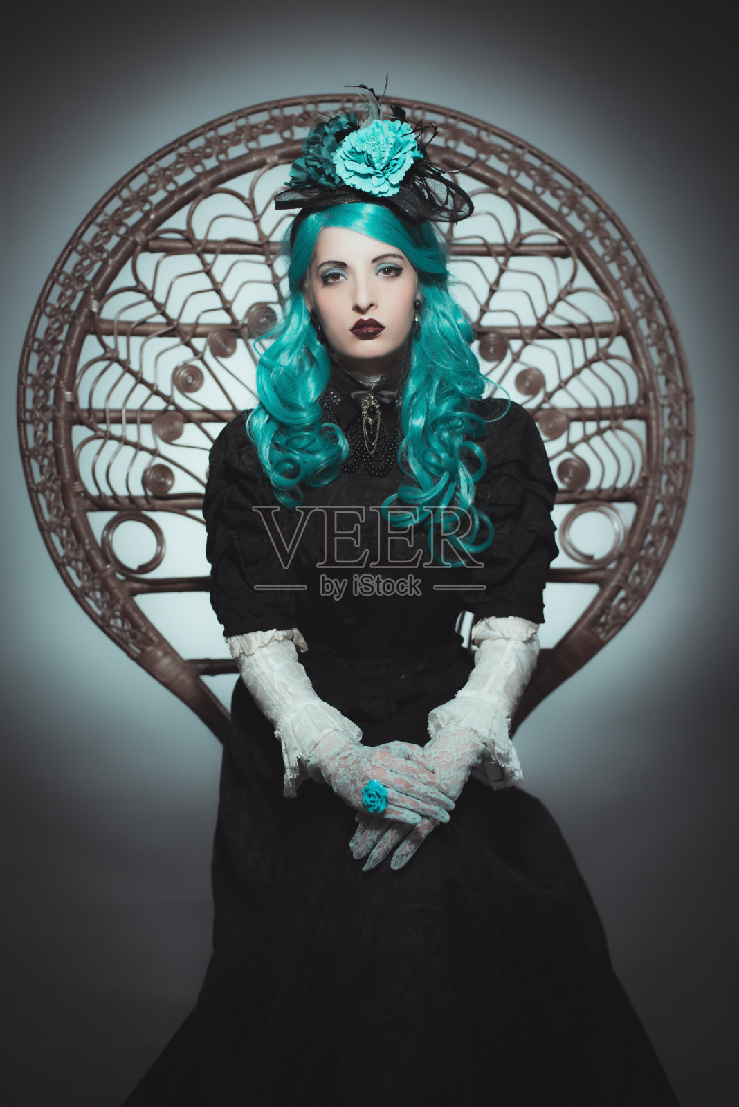 在椅子上穿着复古长袍的绿头发女人照片摄影图片