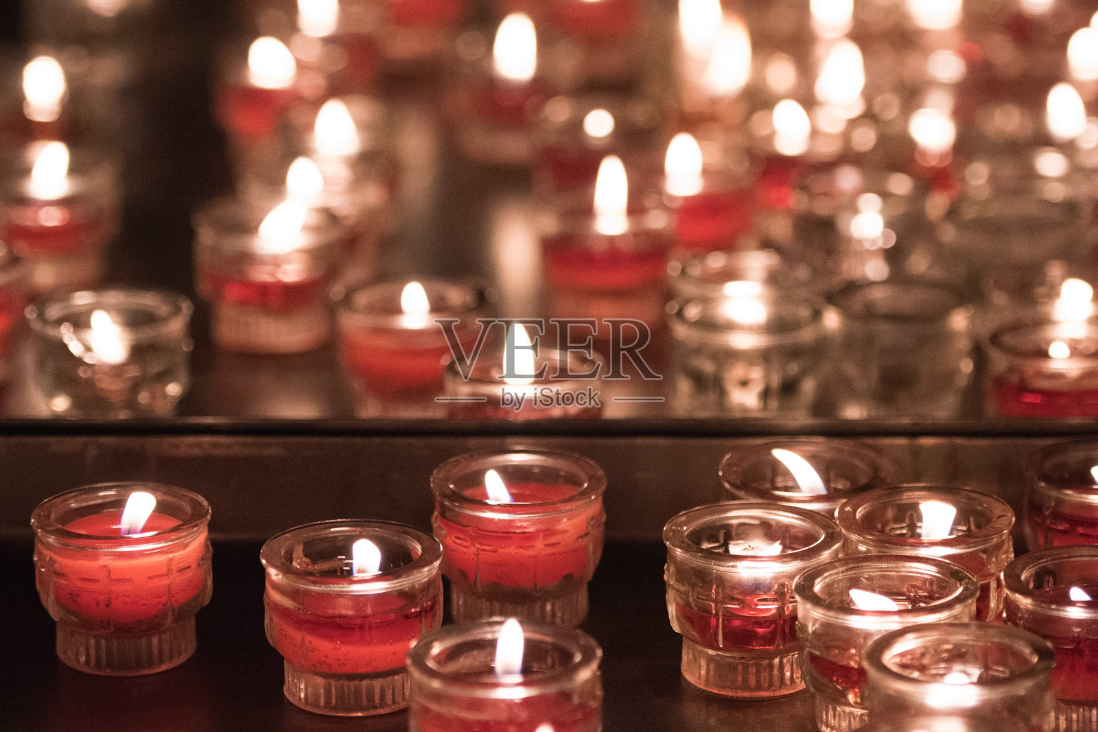 教堂里红色的祈祷蜡烛，白色的火焰照片摄影图片