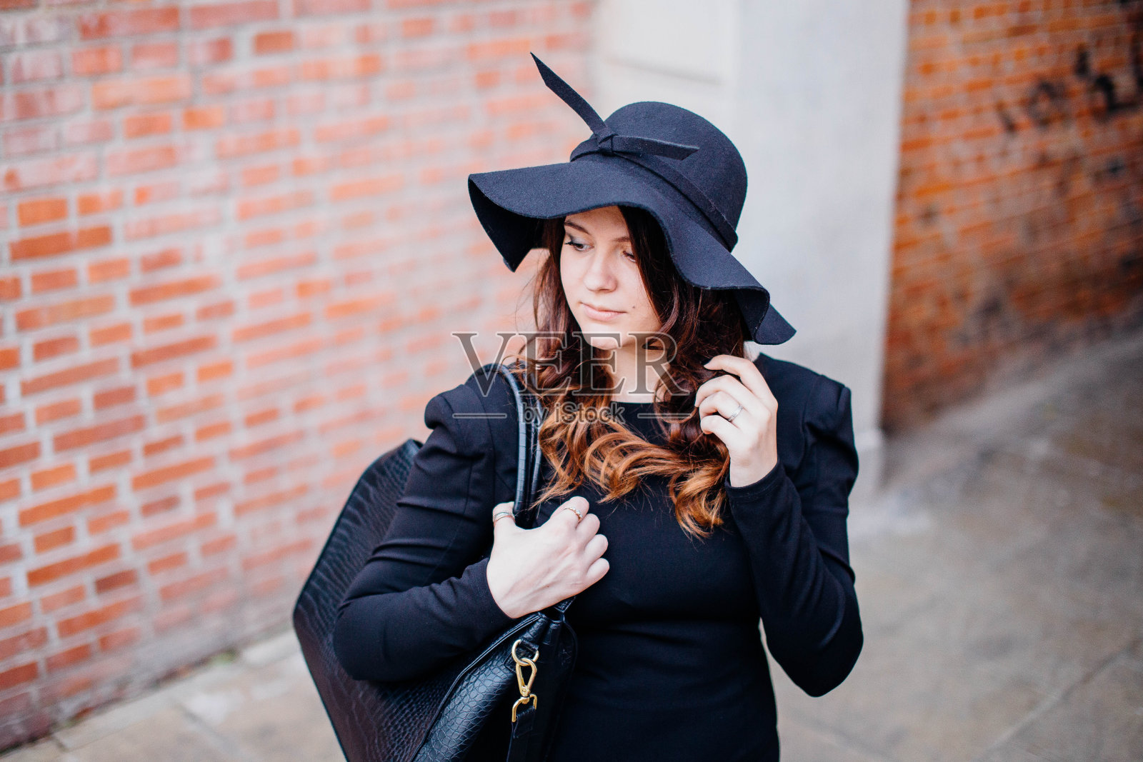 美丽的年轻女孩走在街上。照片摄影图片