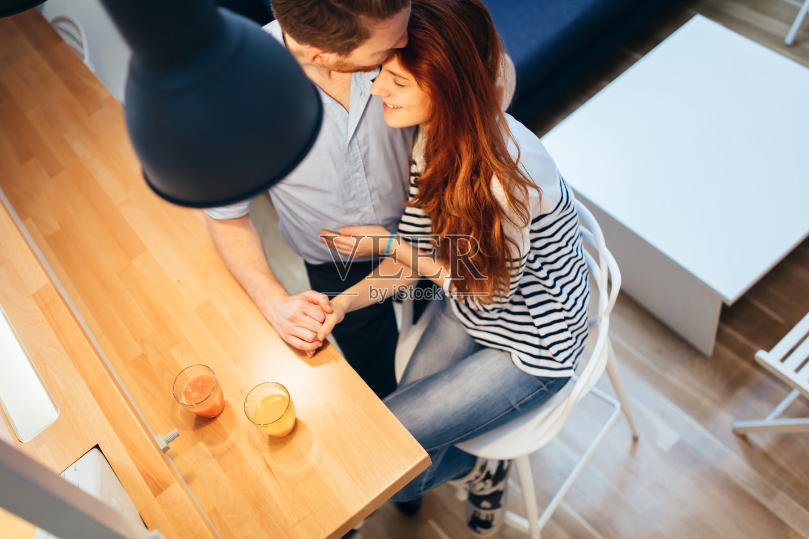 丈夫在新家拥抱和亲吻妻子照片摄影图片