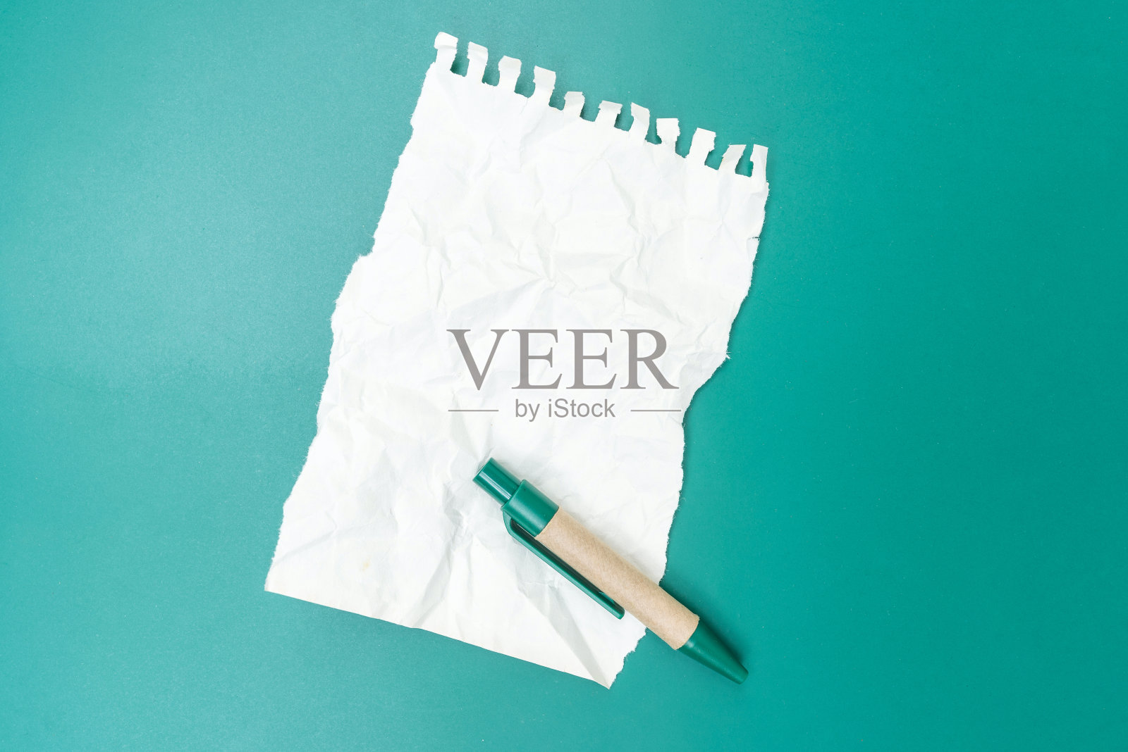 用钢笔和绿色背景揉皱的空白便条纸照片摄影图片