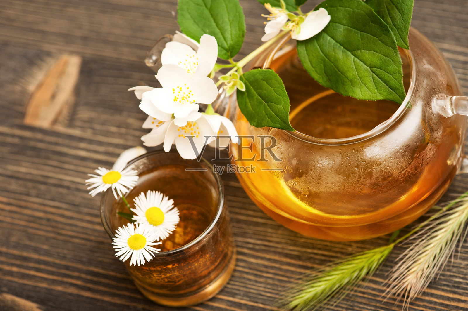 茉莉花茶在一个玻璃水壶在木制的背景照片摄影图片