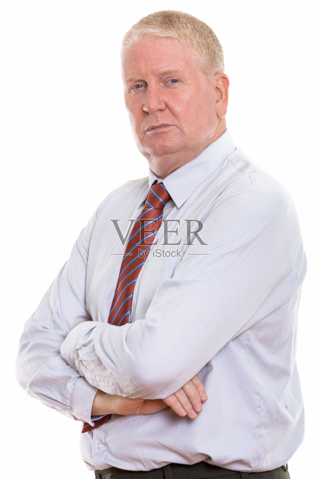 工作室拍摄的一个成熟的商人双臂交叉看着相机照片摄影图片