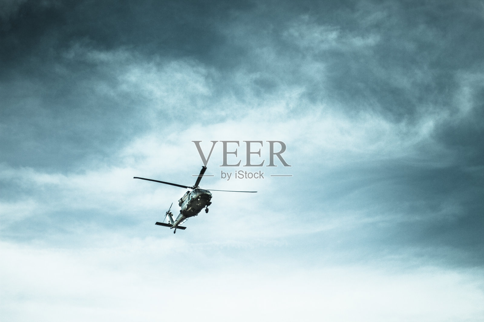 暴风雨天空中的直升机照片摄影图片