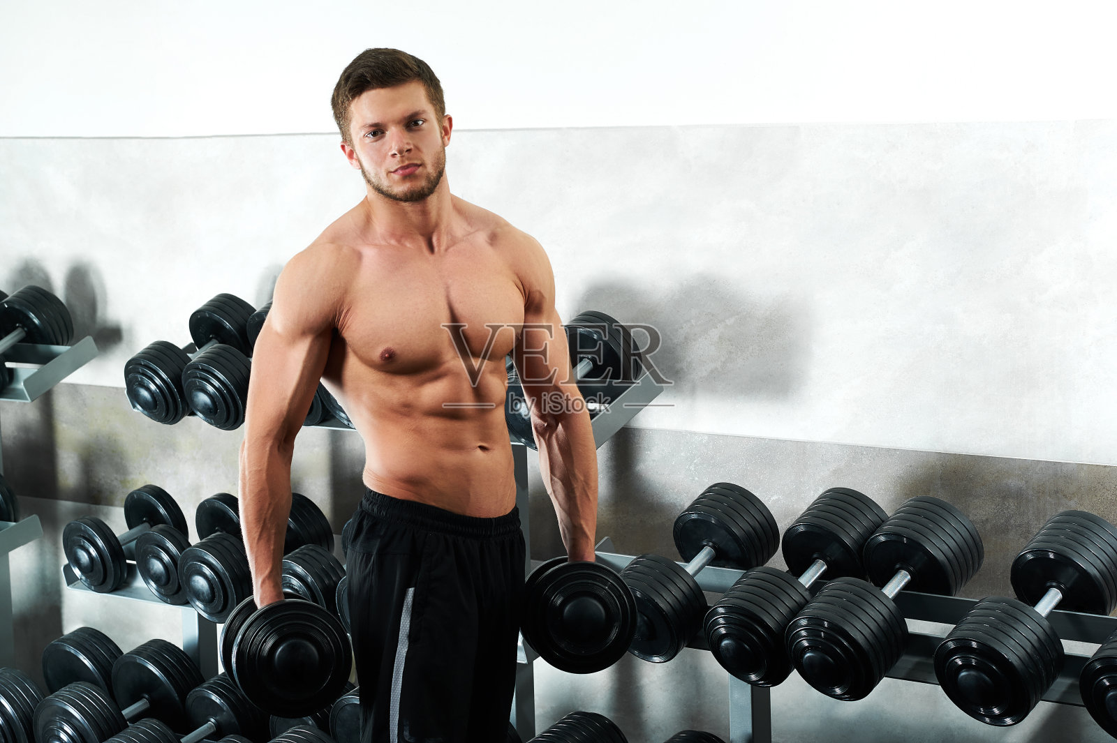 在健身房锻炼的帅气年轻运动员照片摄影图片