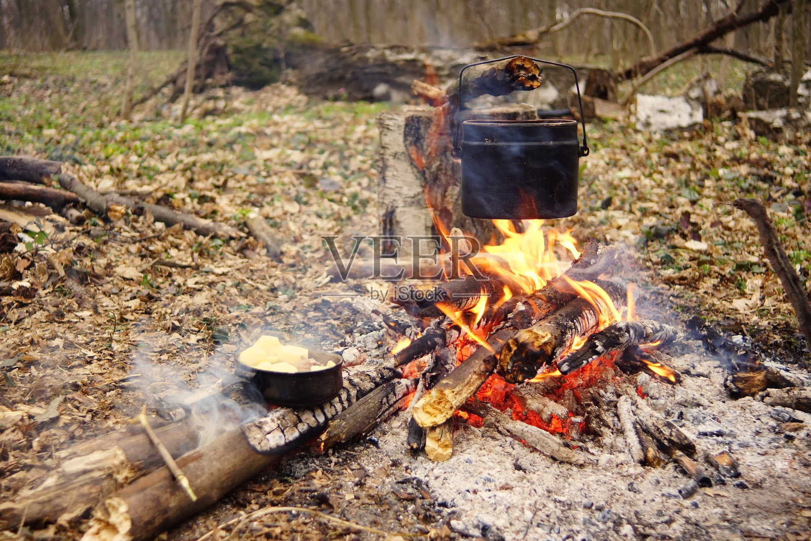 旅游水壶在营火和帐篷背景。a .用棍子处理火照片摄影图片