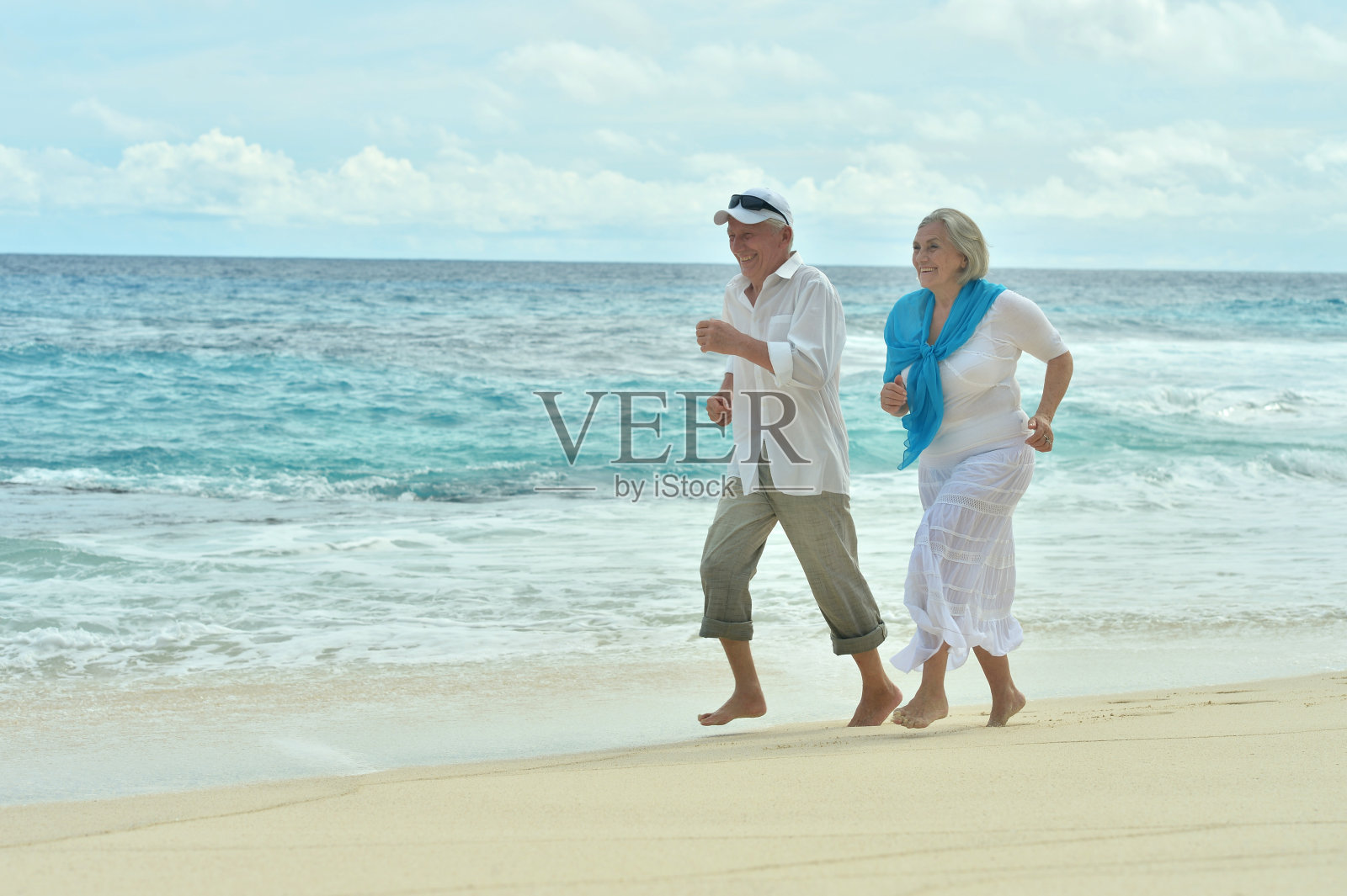 一对老年夫妇在海滩上跑步照片摄影图片