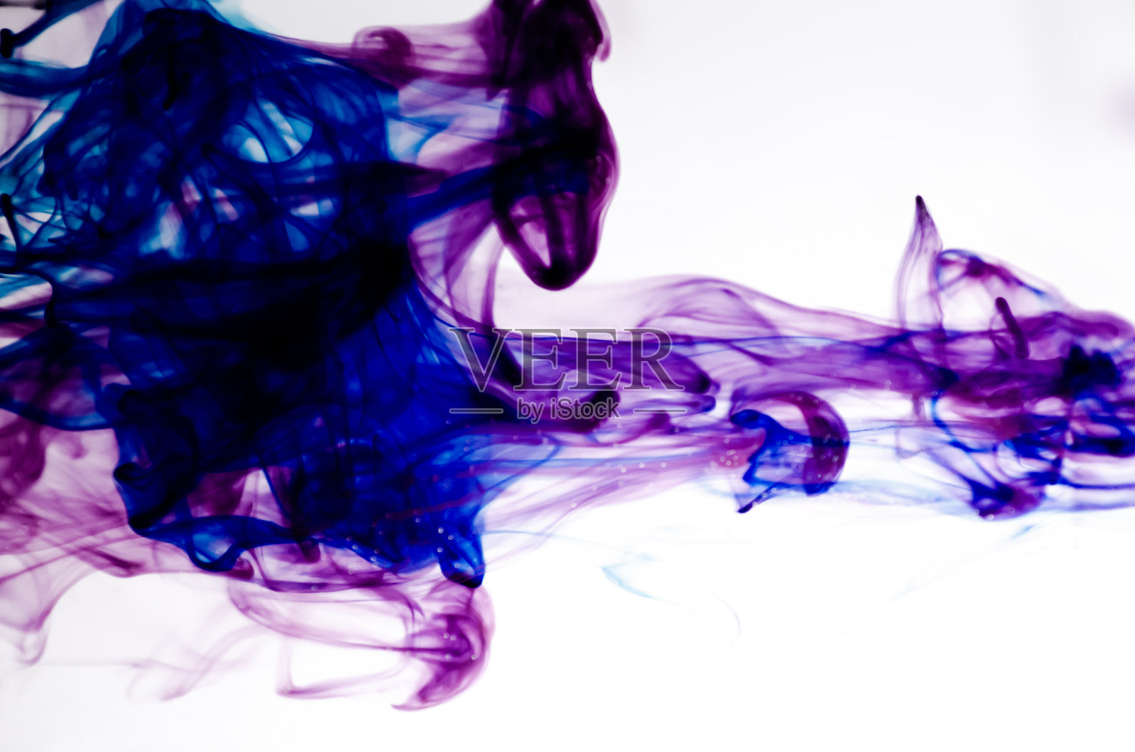 颜色进入液体，在运动中拍照。白色背景上的水墨汁云照片摄影图片