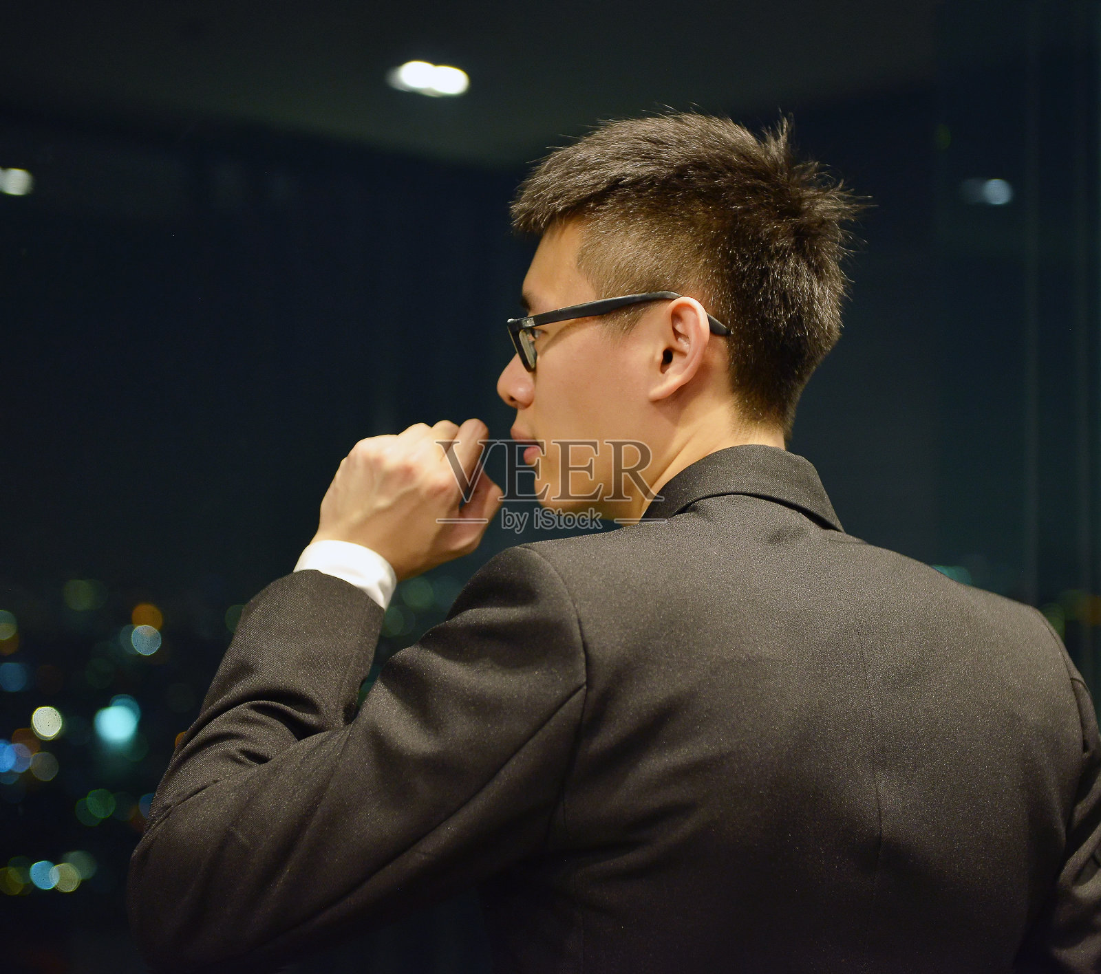 背对亚洲商人思考的夜晚与散景的灯光城市照片摄影图片