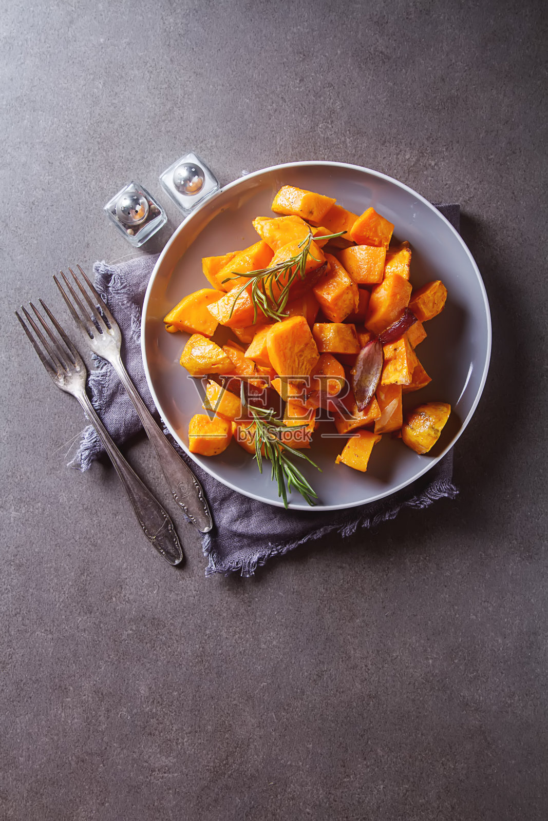 加洋葱和迷迭香的红薯。黑暗的背景。照片摄影图片