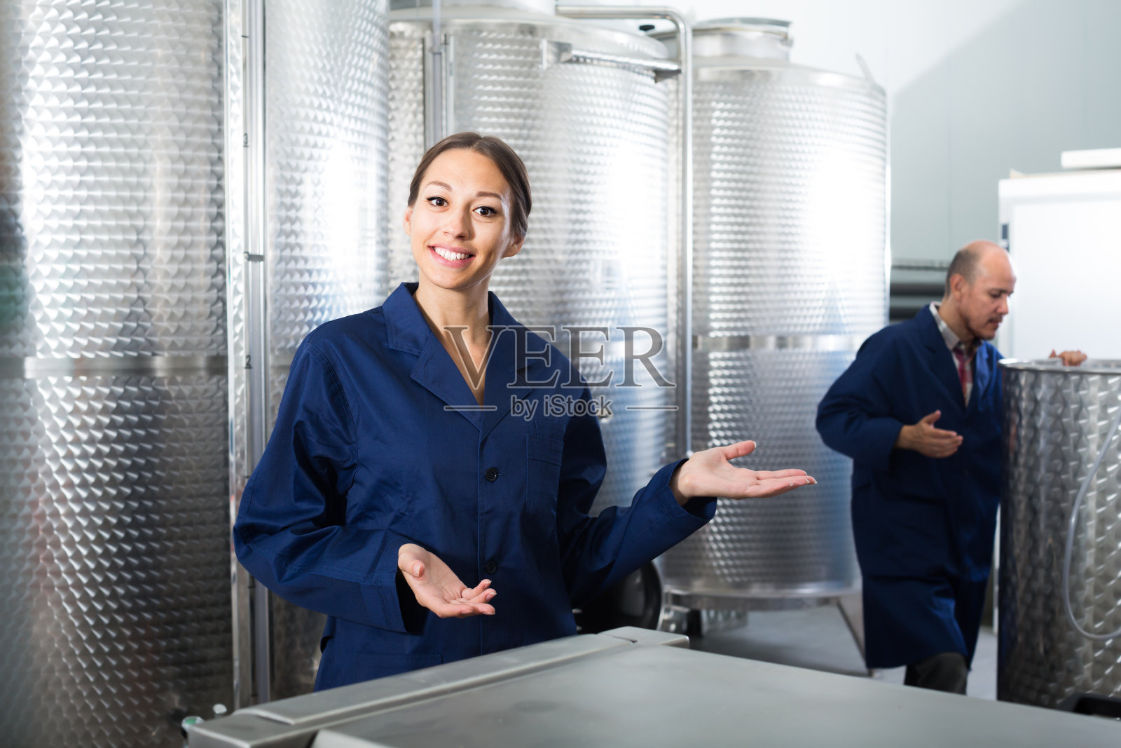 身穿制服的快乐女人站在葡萄酒区照片摄影图片