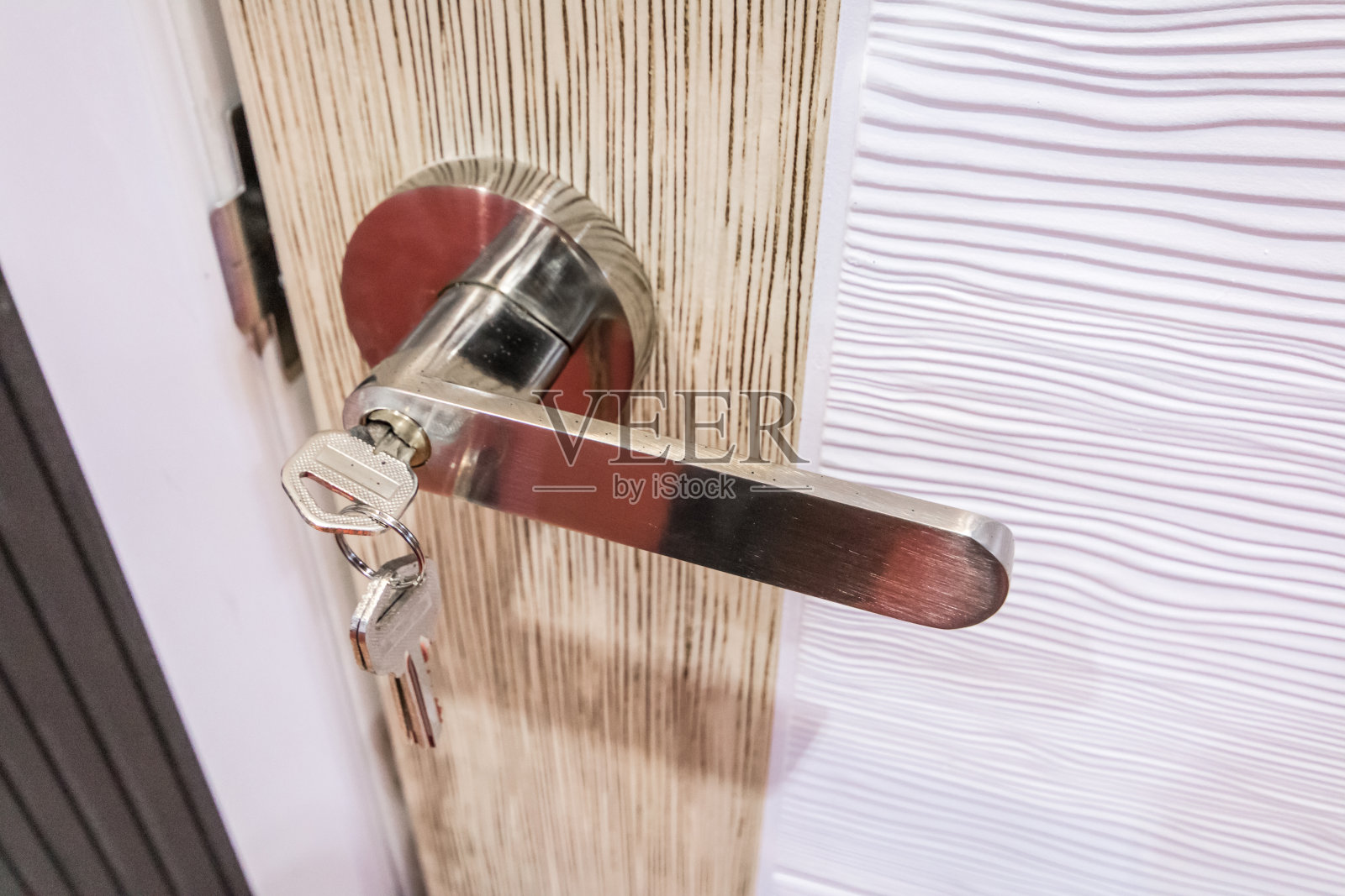 现代风格的门把手放在天然木门上照片摄影图片