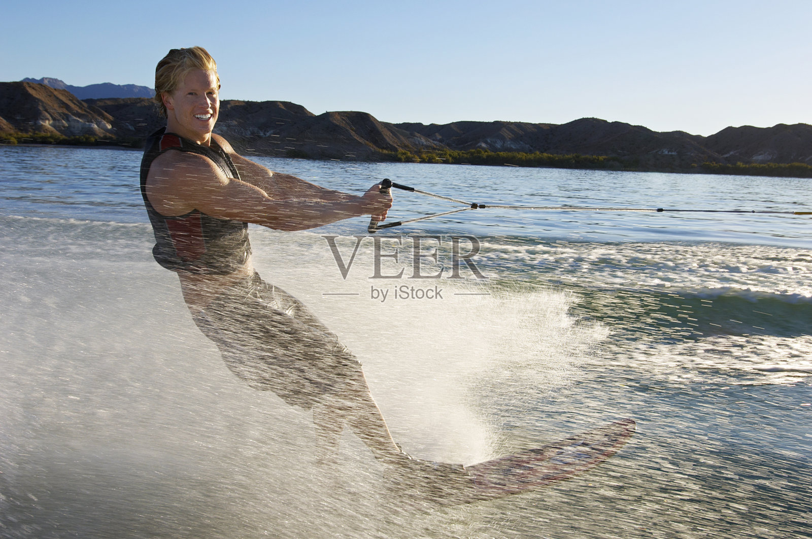 一个快乐的年轻人在湖上冲浪照片摄影图片
