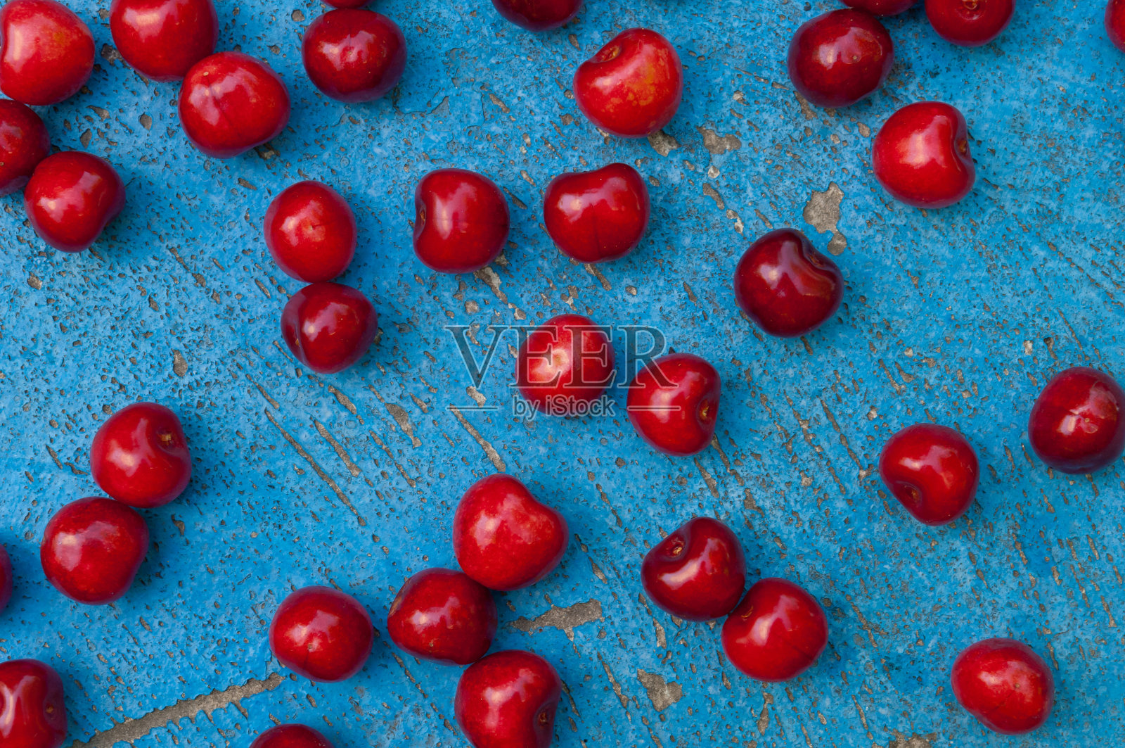 在蓝色纹理背景上排列成熟的樱桃照片摄影图片