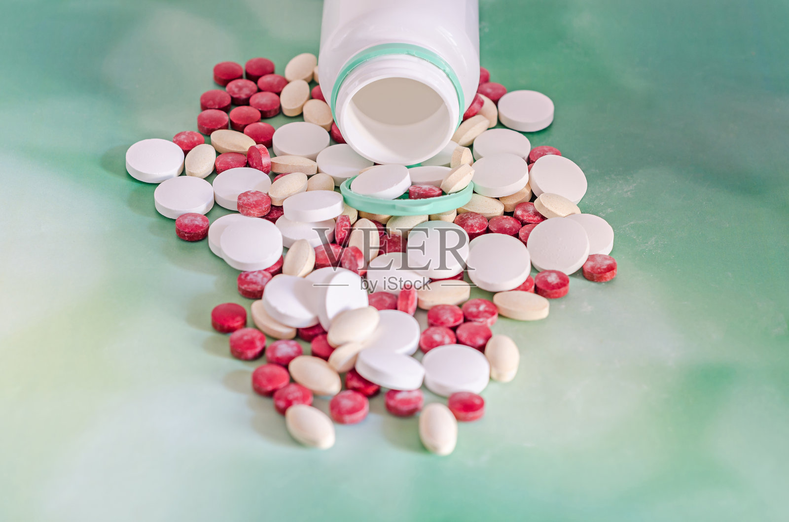 红色、白色、黄色的药丸用白色的塑料瓶开着照片摄影图片