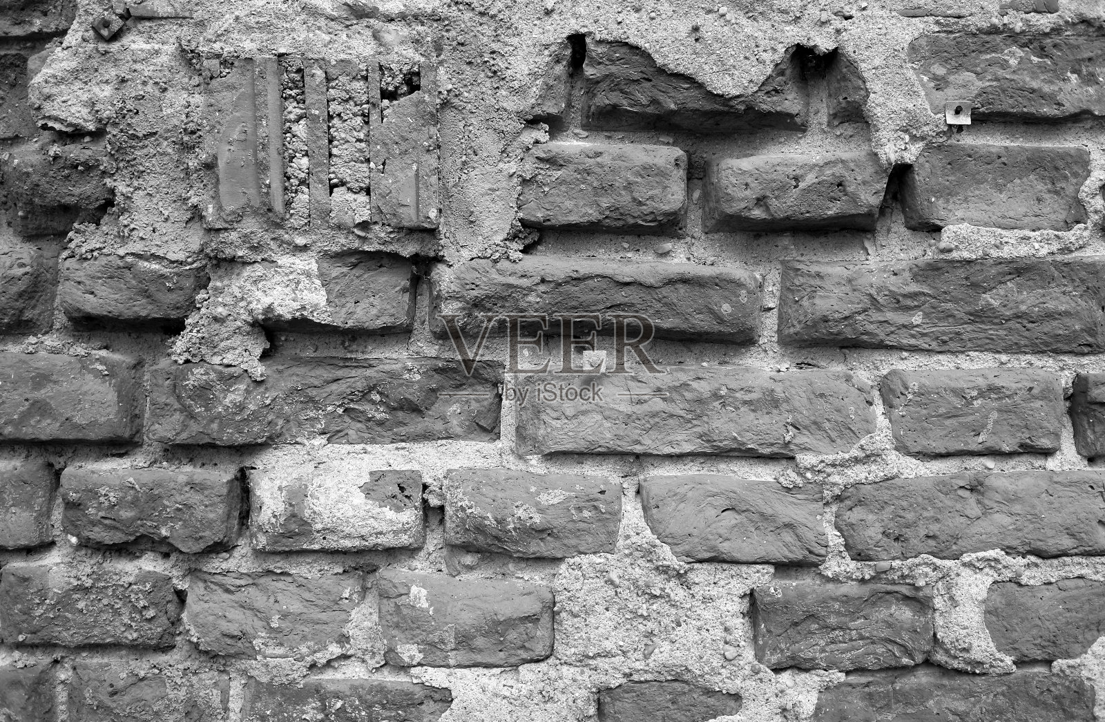 砖石砌筑:旧的、修补不善的、接缝平齐的坚固砖墙照片摄影图片