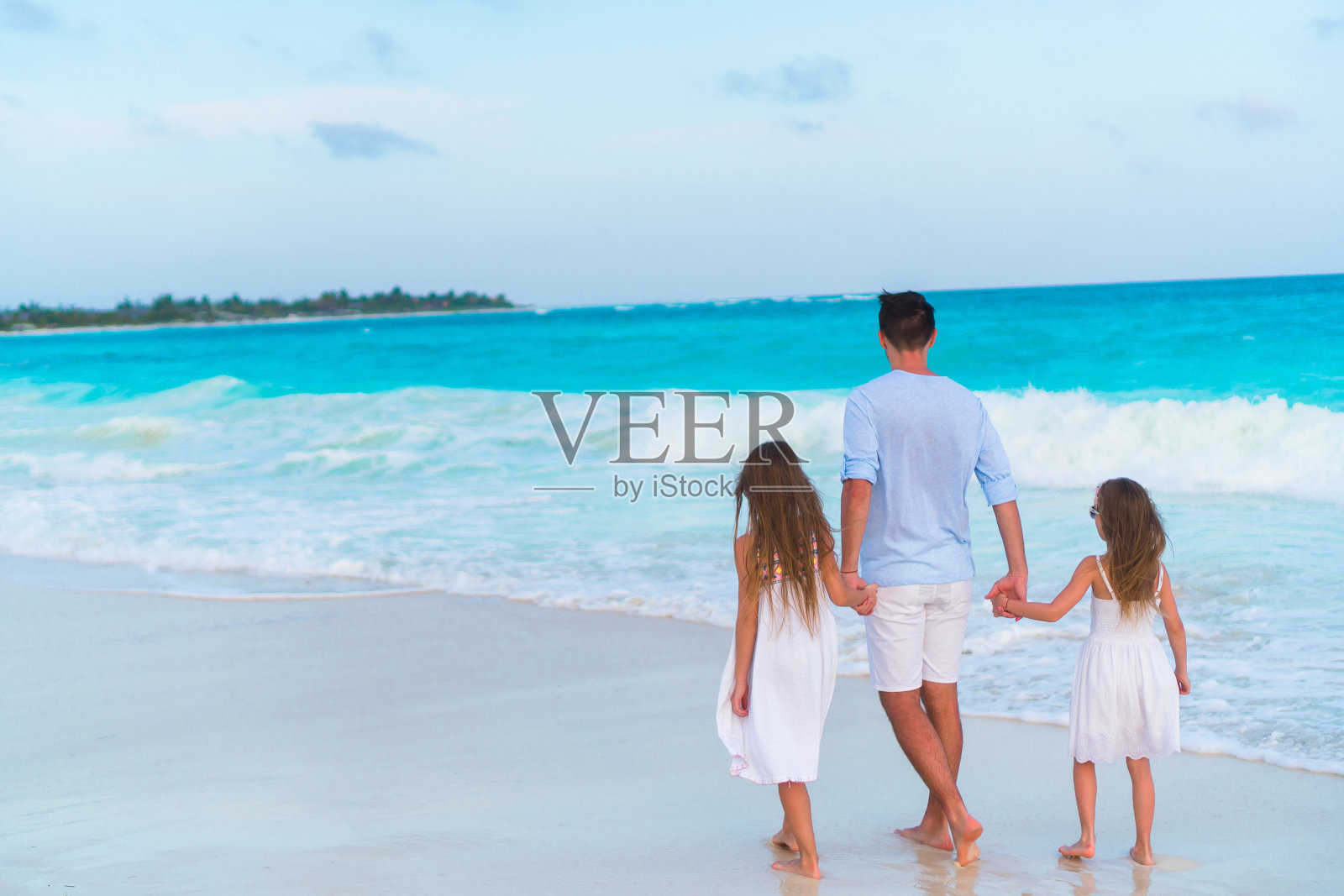 一家人晚上在加勒比岛的白色沙滩上散步照片摄影图片