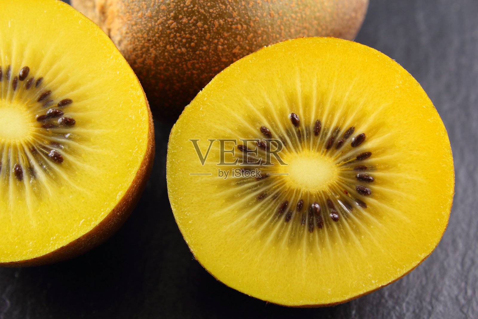 新鲜的黄色猕猴桃放在石板盘子里照片摄影图片