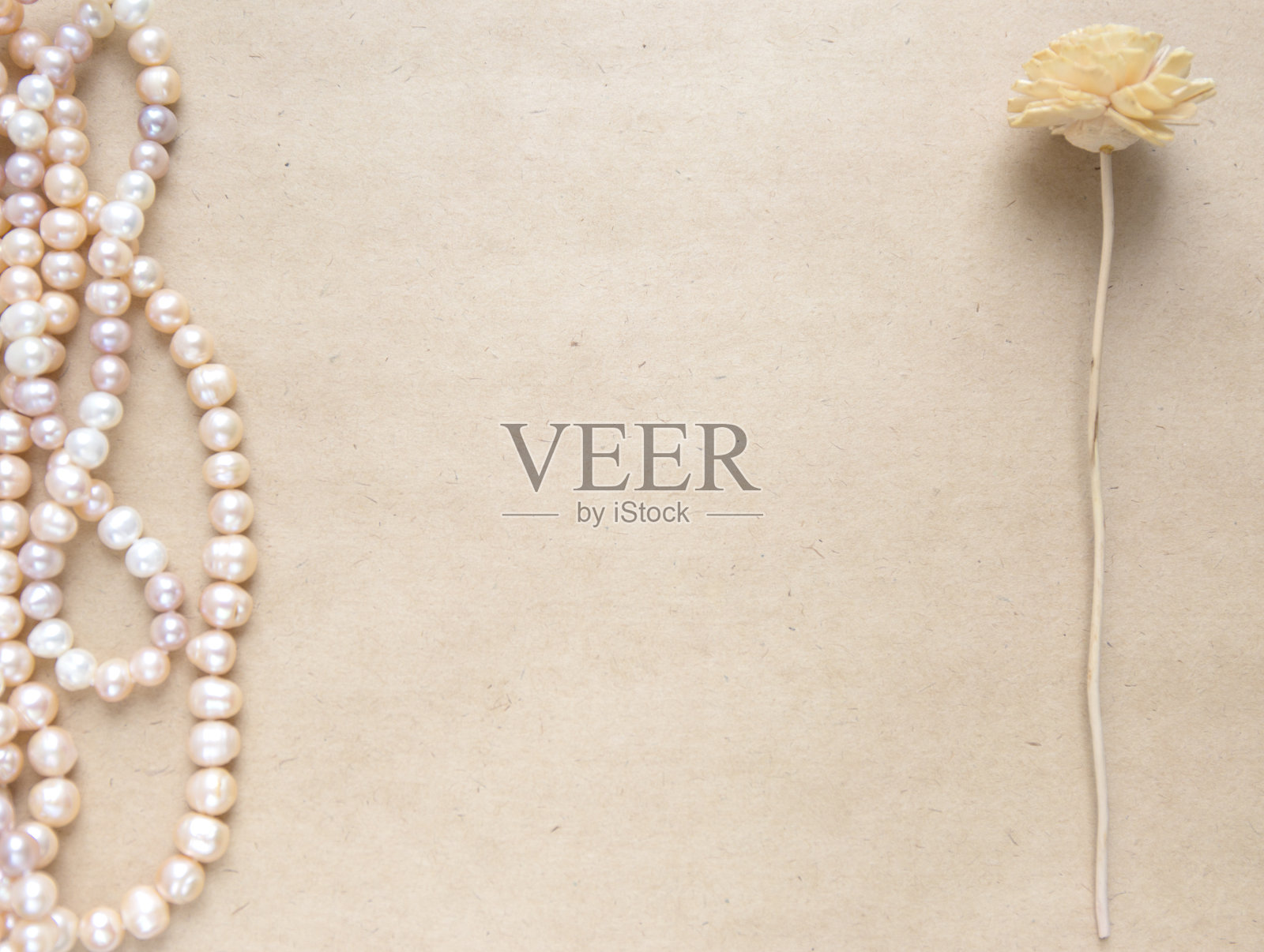 空白工艺背景。一张粗糙的纸，上面有玫瑰珍珠和鲜花。模拟写信，创造性的工作概念照片摄影图片