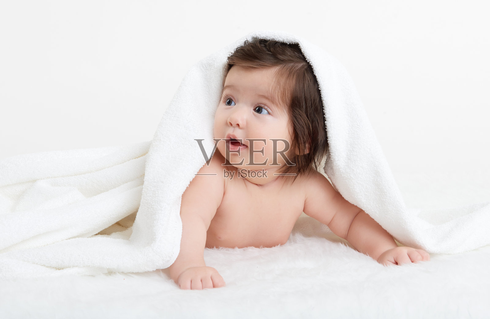 可爱的婴儿躺在床上白色的毛巾。快乐童年，健康理念照片摄影图片