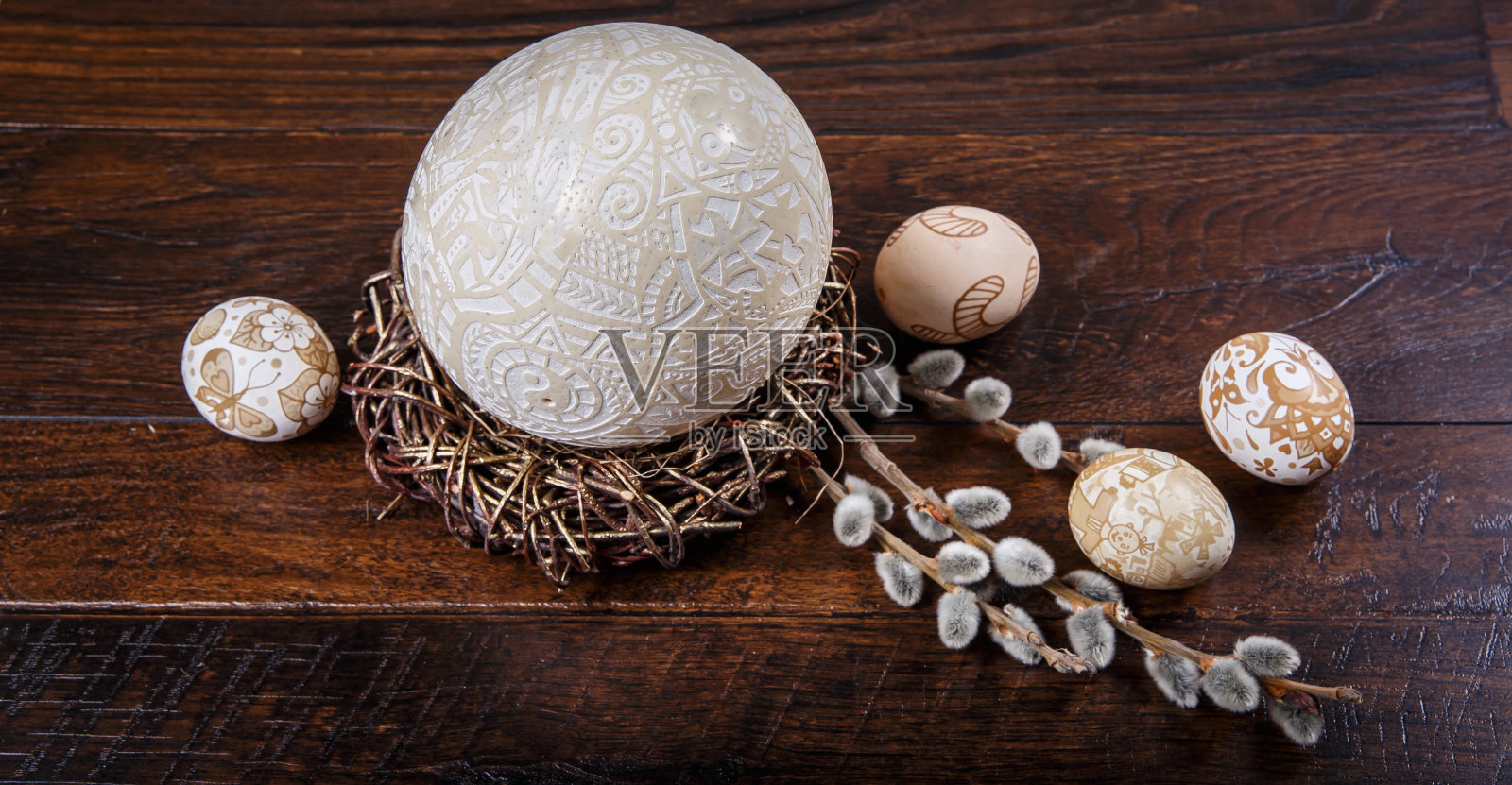 复活节主题。在木质纹理上手绘复活节彩蛋和带花的柳枝照片摄影图片