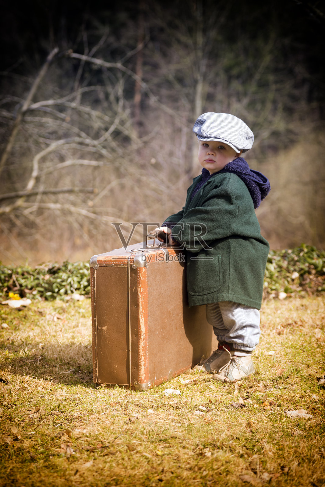 携带复古手提箱的孤独男孩照片摄影图片