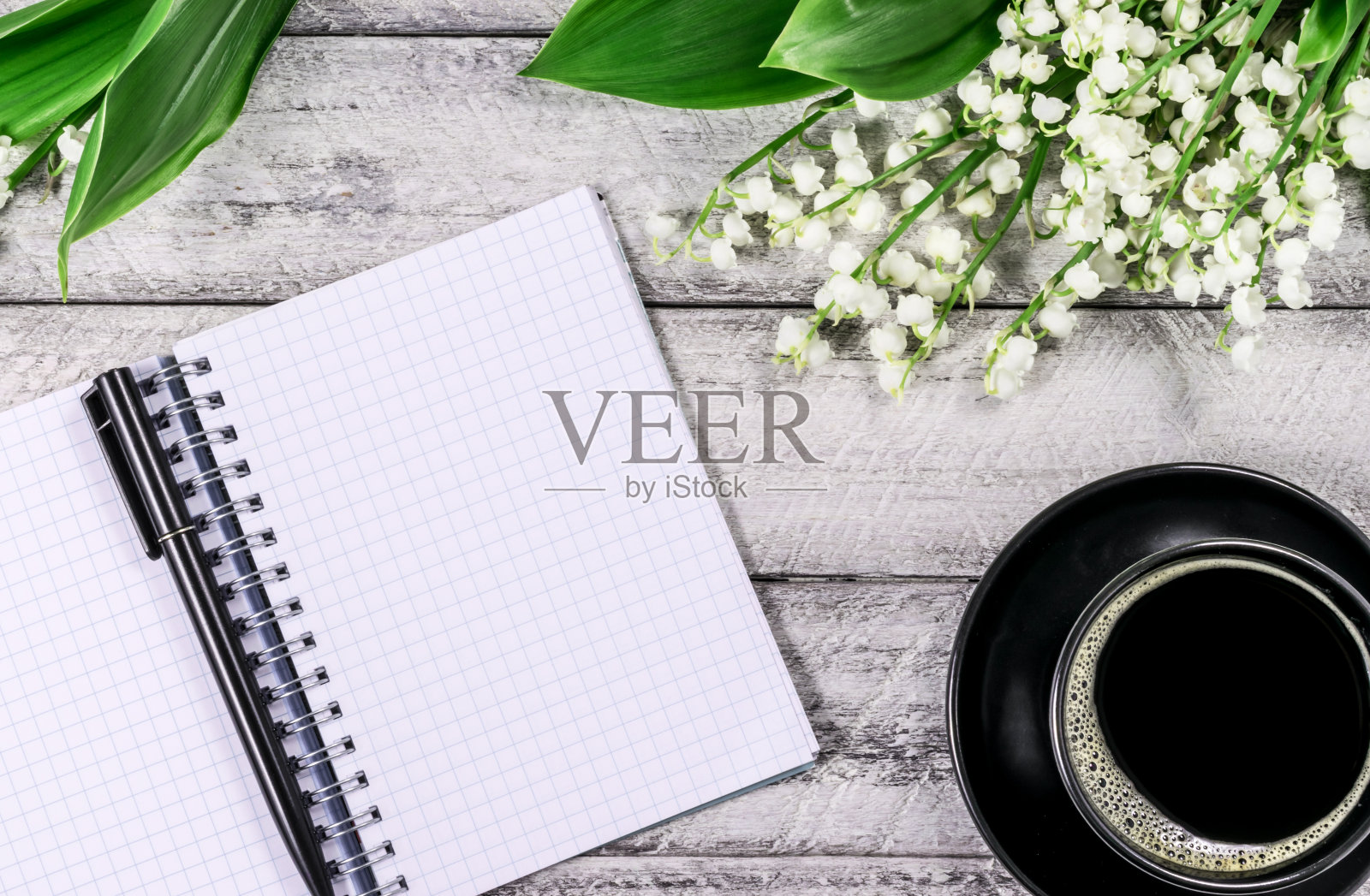 木桌上放着花。副本的空间。有笔记本和咖啡杯的工作空间。照片摄影图片