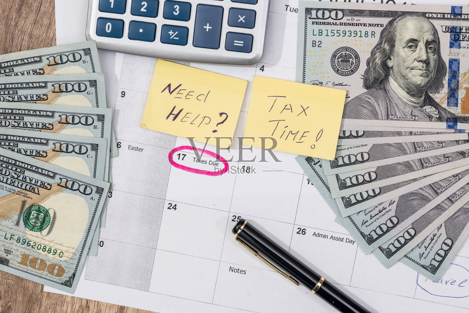 4月15日，税务日日历上用红色记号笔与美元纸币、笔和计算器。照片摄影图片