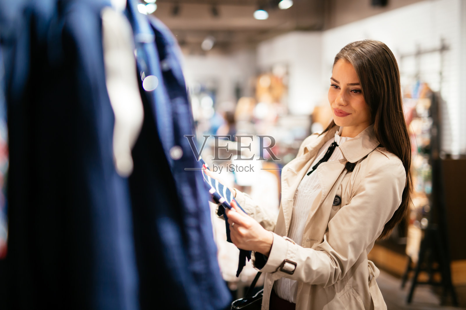 漂亮的黑发女人选择和购买衣服照片摄影图片