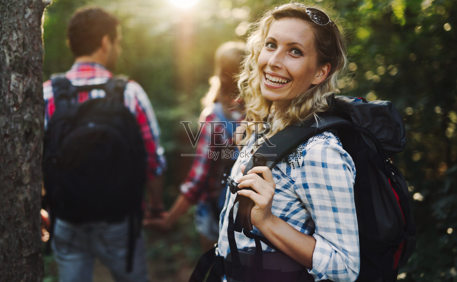 美丽的女人和朋友徒步旅行和背包在森林照片摄影图片