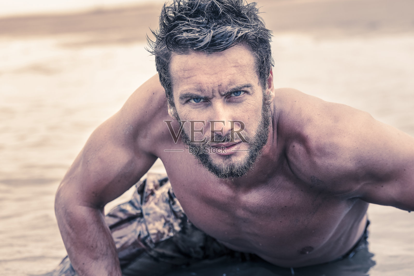 英俊的赤膊军队在海水中爬行照片摄影图片