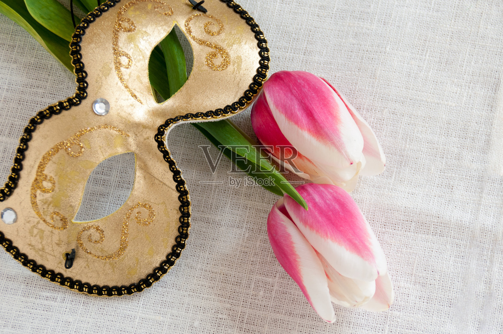 红色和白色郁金香金色面具在白色亚麻织物照片摄影图片