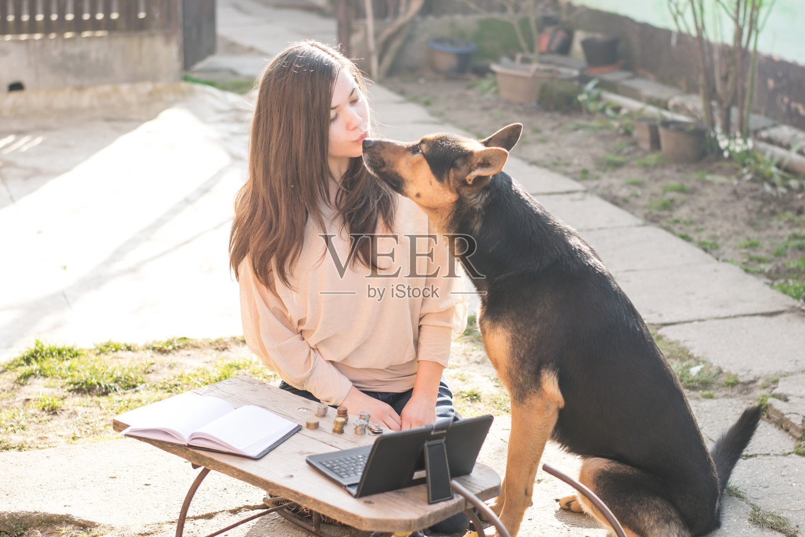 女孩亲吻她的黑狗照片摄影图片