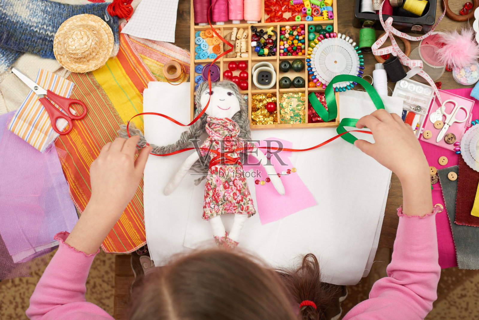 女孩缝制娃娃衣服，俯视图，缝纫配件俯视图，裁缝工作场所，许多对象的刺绣，手工和手工艺品照片摄影图片