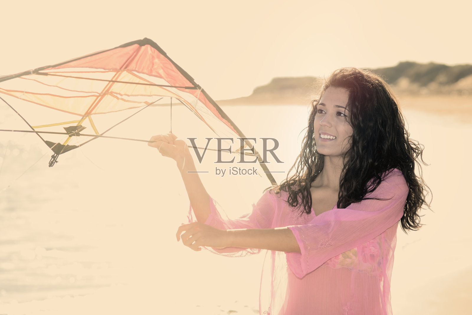 黑发女孩微笑着用风筝温暖的过滤器照片摄影图片