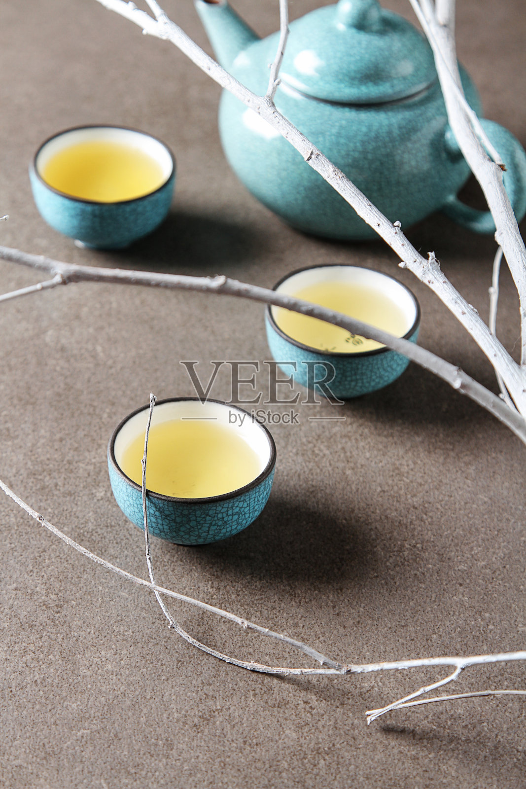 瓷杯，钢茶匙。红茶，绿茶，普洱，乌龙茶，铁观音，煎茶，茶。灰色的背景。照片摄影图片