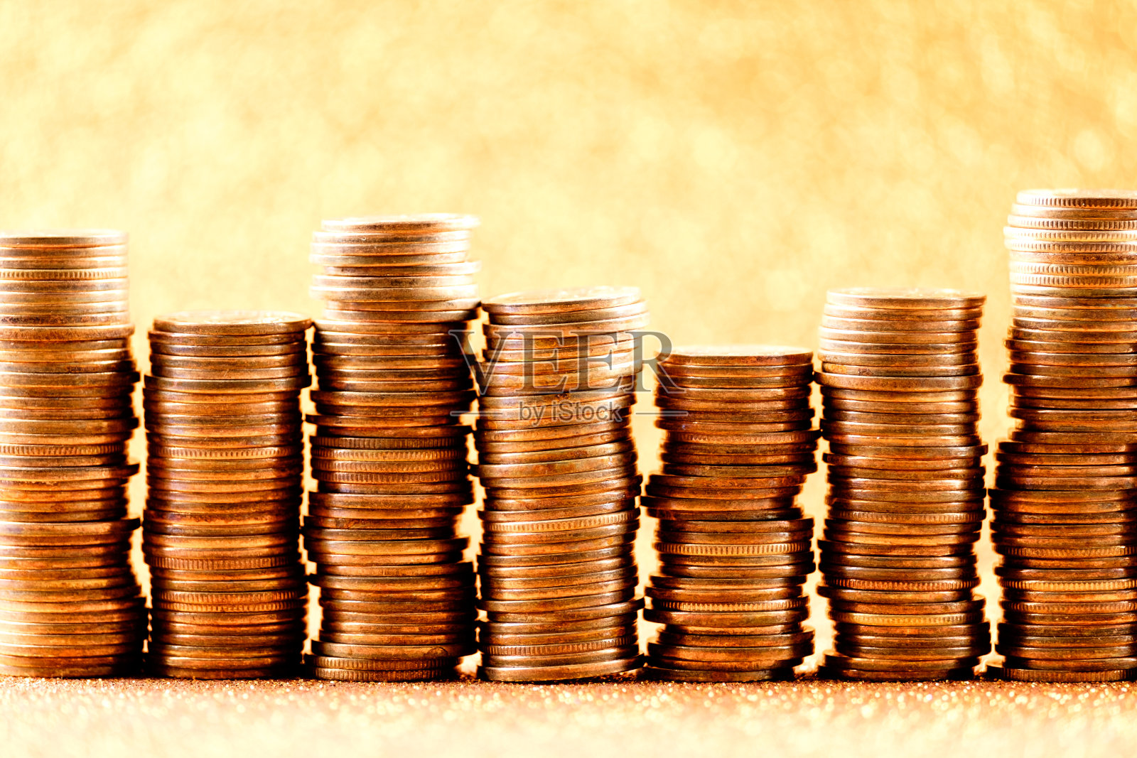 成堆的金币作为一个图形排列在闪闪发光的背景上。金融概念照片摄影图片