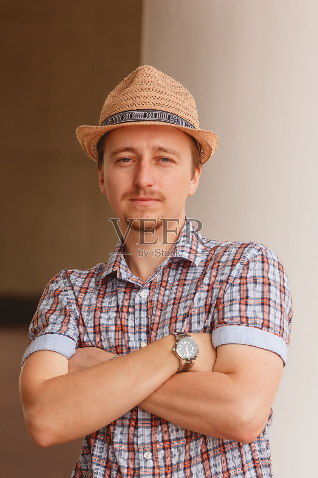 一个戴着帽子的开朗时髦的家伙靠在户外的墙上照片摄影图片