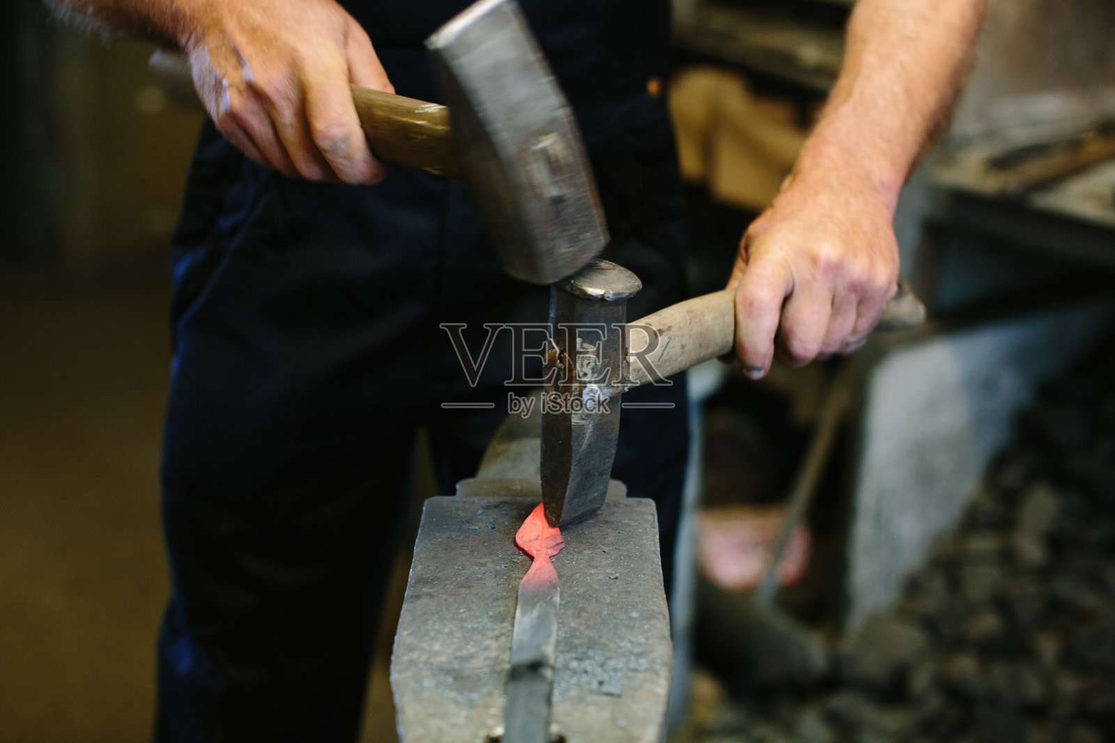 铁匠在锻炉的铁砧上用铁锤加工金属照片摄影图片