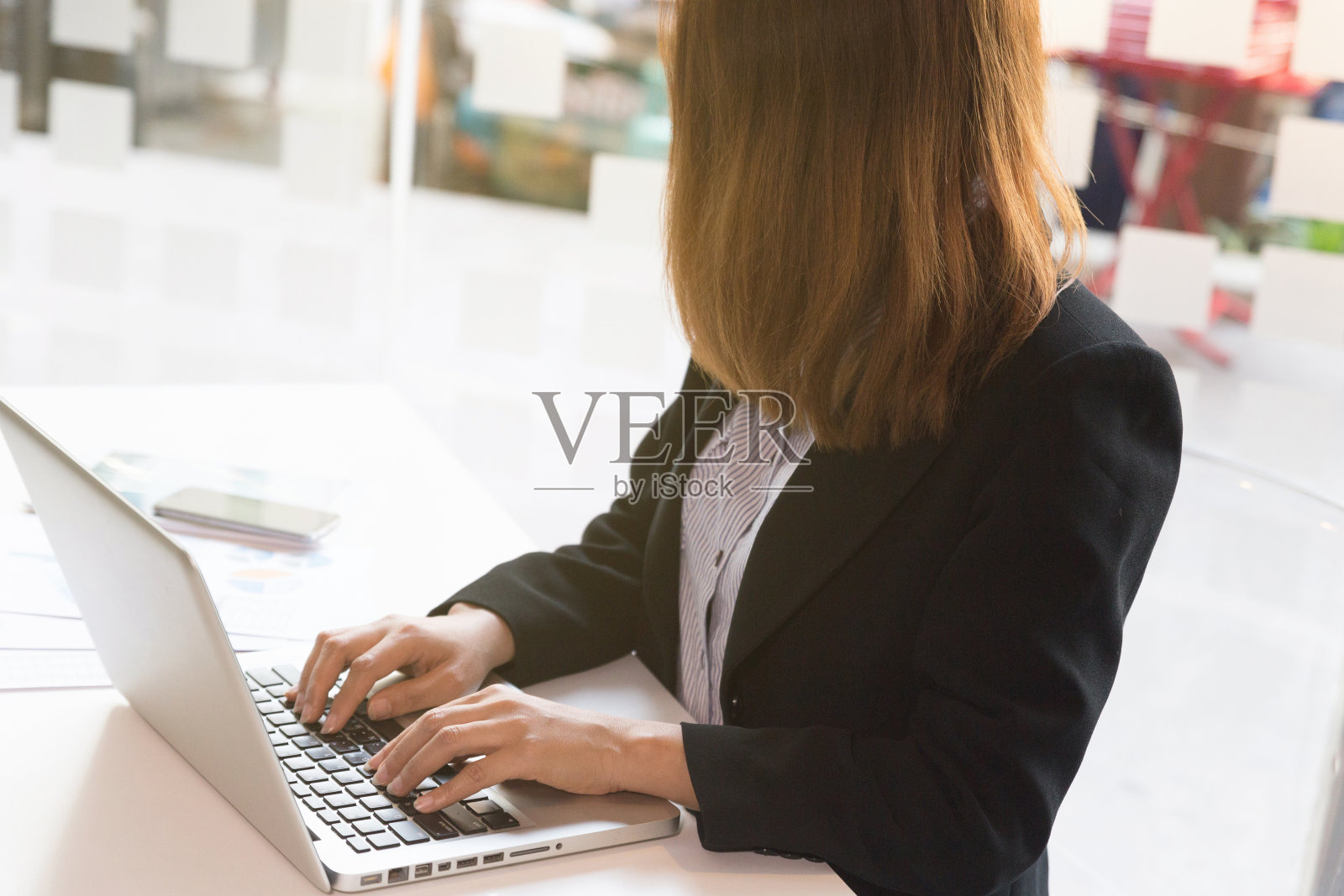 办公室里使用笔记本电脑和金融图表的商务女性照片摄影图片