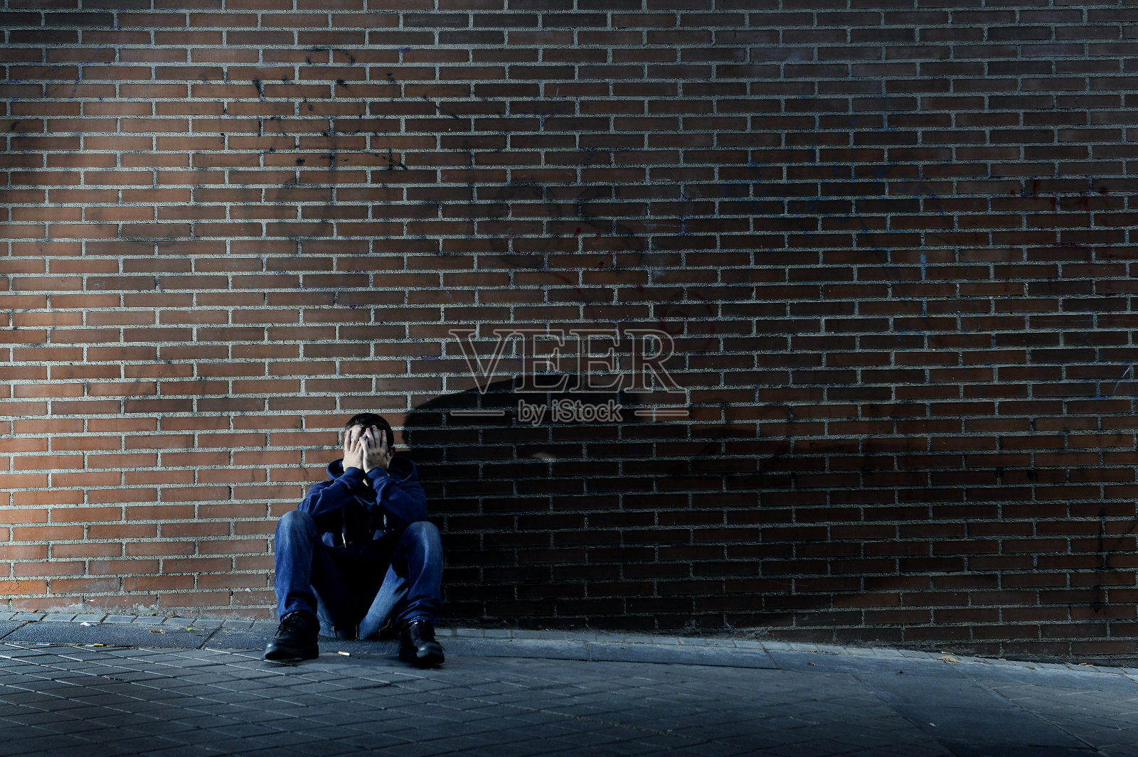 年轻绝望的失业流浪汉坐在街上照片摄影图片