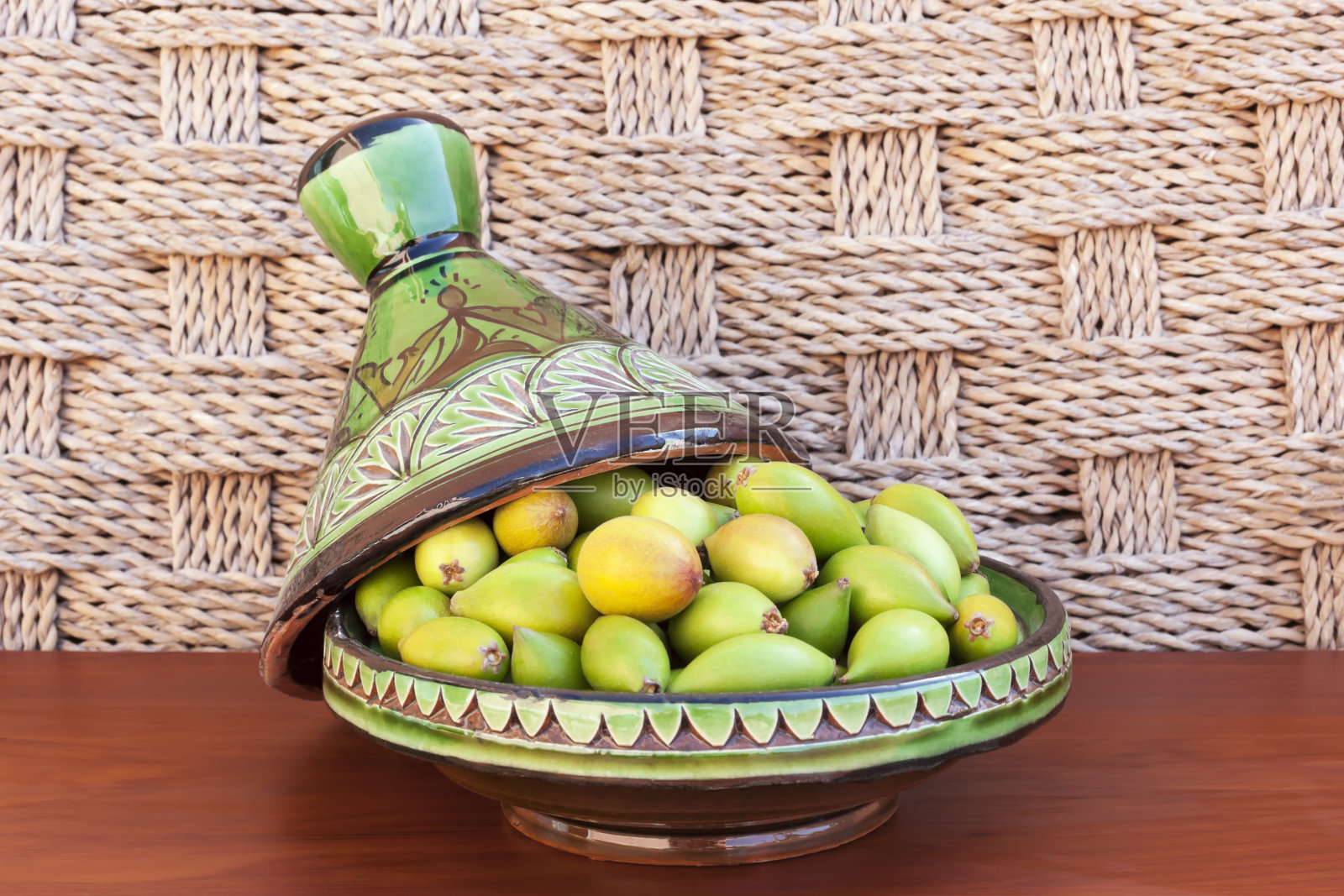 绿色盘子里的坚果。照片摄影图片