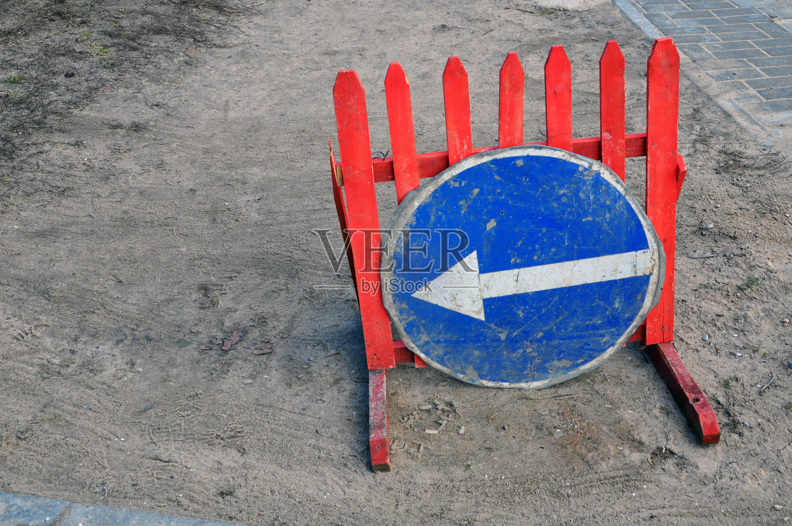 红色木栅栏上的路标“向左拐”。照片摄影图片