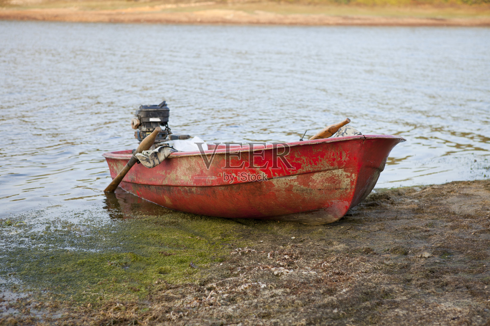 湖边一条红色的旧划艇照片摄影图片