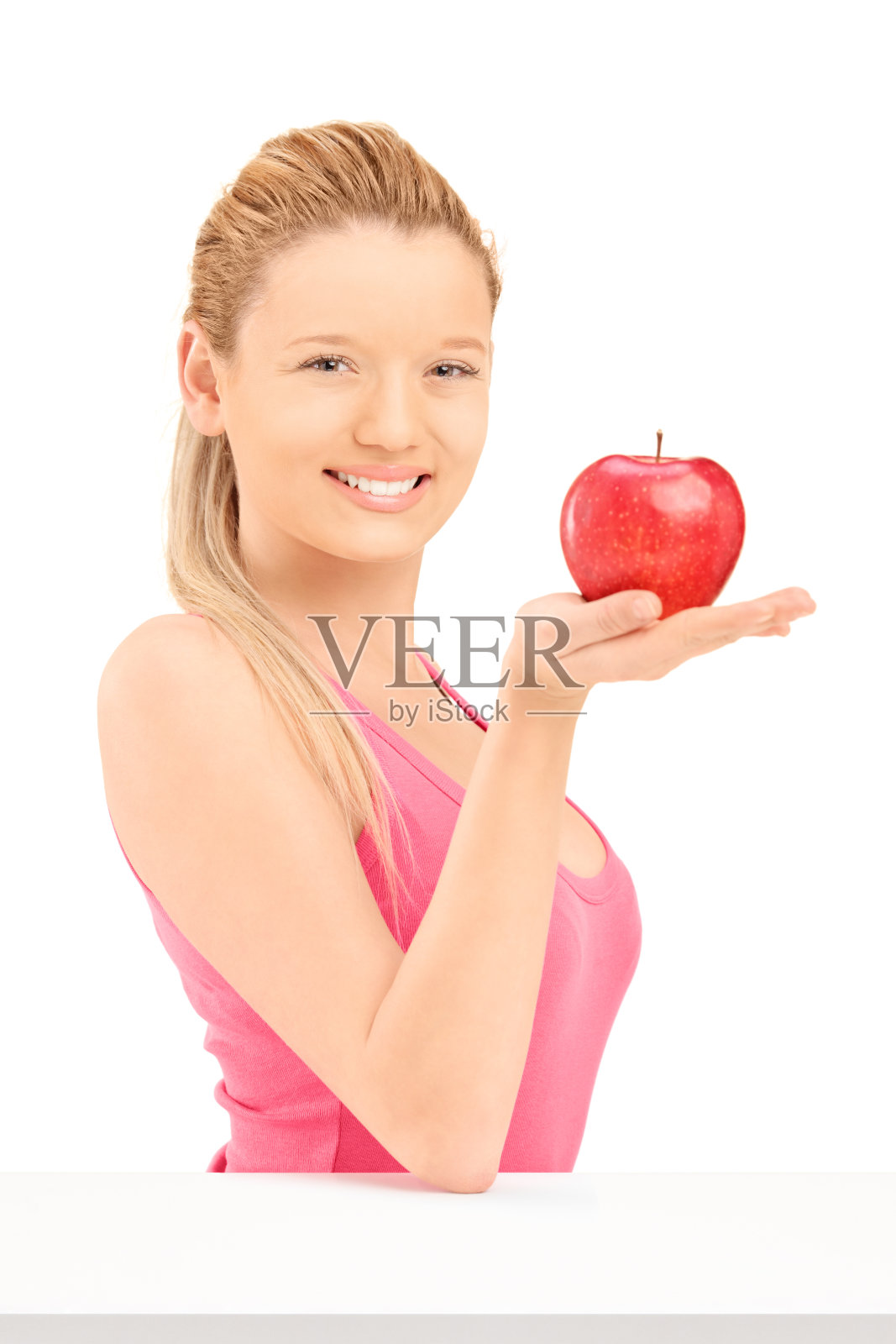 年轻的微笑女人拿着一个红苹果照片摄影图片