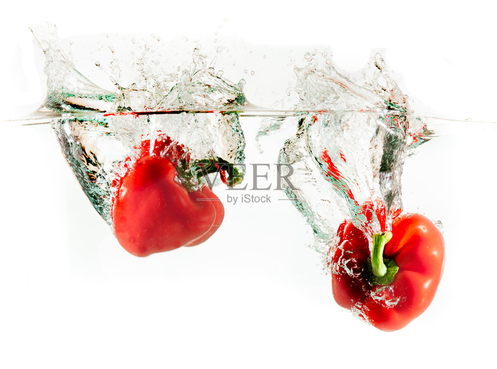 红辣椒在水中，白色背景上有斑点照片摄影图片