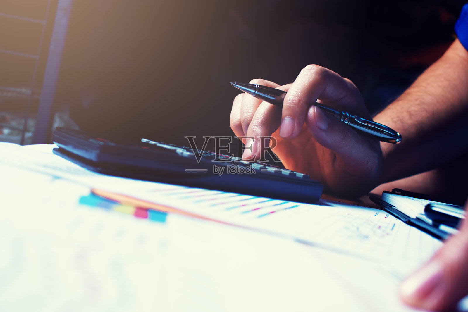 女人用手拿着笔打字计算器，计算财务。照片摄影图片